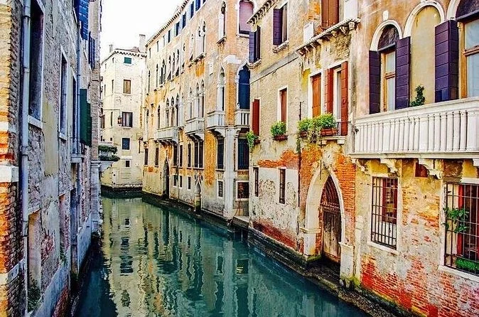 Ein ruhiger Kanal in Cannaregio mit an den Häusern festgemachten Booten und niemandem auf der Fondamenta